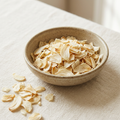 Illustrative image of dried garlic flakes in a ceramic bowl